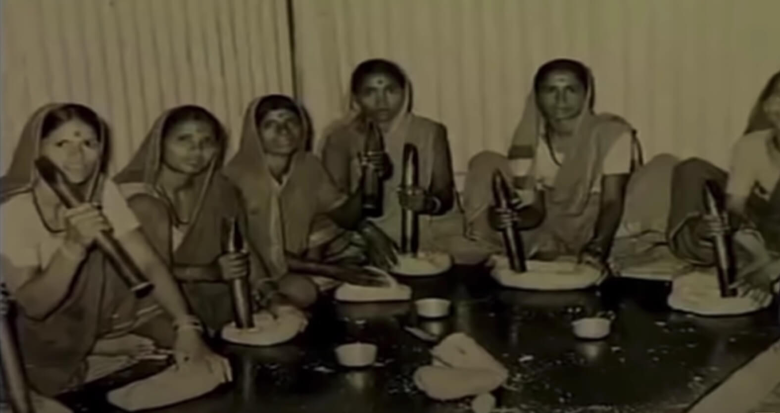 Women in traditional attire making papads, representing the early beginnings of Lijjat Papad. 