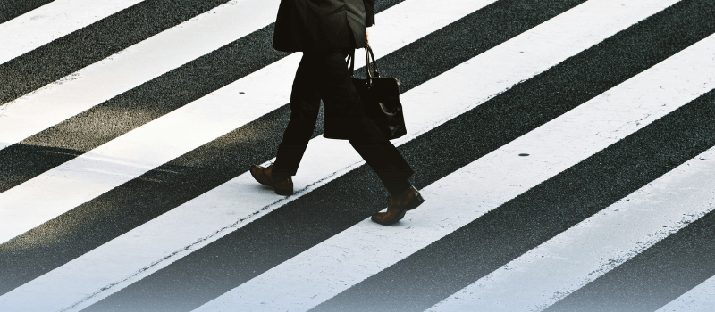 A businessman walks across a crosswalk, symbolizing organic growth in venture capital and private equity.