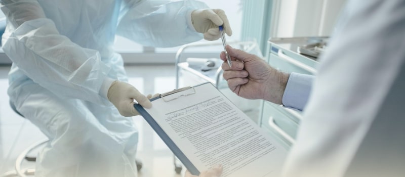 A patient signing medical documents in a hospital, symbolizing the growing role of financing in healthcare access.