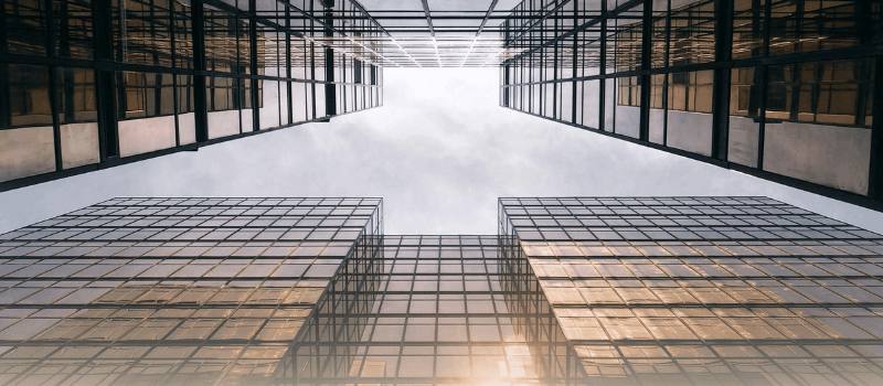 Upward view of modern glass skyscrapers symbolizing the rise of institutional investors in India’s private markets, financial growth, and structured capital deployment