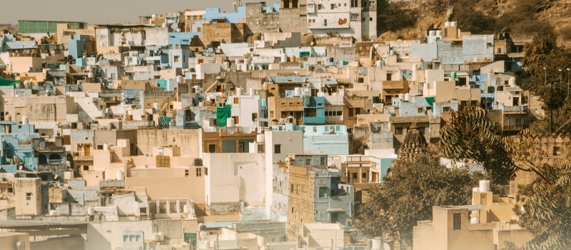 A dense cluster of colorful buildings in a small Indian city, symbolizing the rise of healthcare access beyond metros.