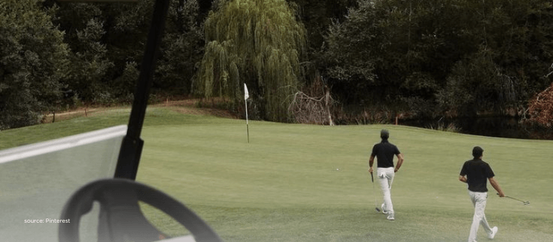 Two people playing golf on a green course, symbolizing patience and long-term strategy in private equity.