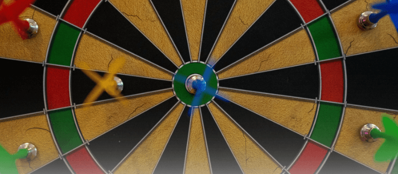 Dartboard with darts near the bullseye, symbolizing precision and valuation discipline in unlisted investing.