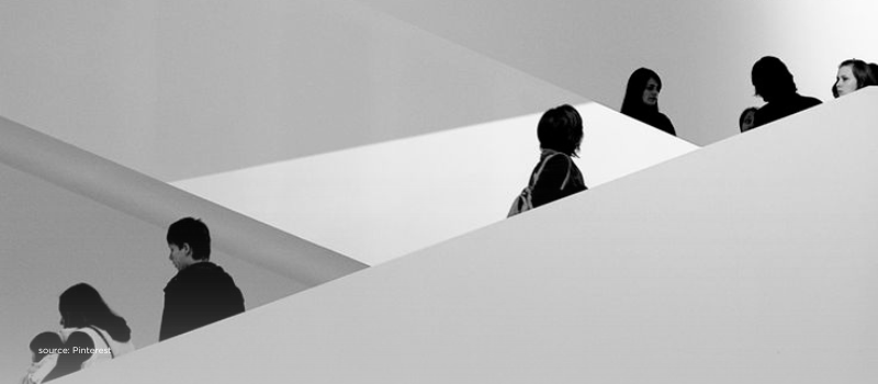 People moving along intersecting ramps in a minimalist building, conveying steady layered progress that benchmarks India against Western VC stability.