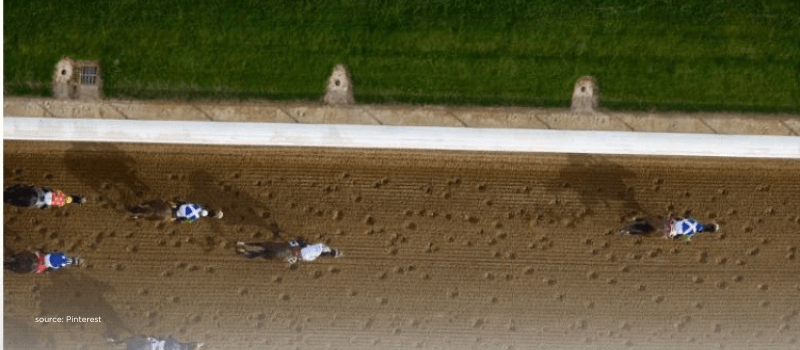 Overhead view of horses on a track, reflecting slower startup graduation races.