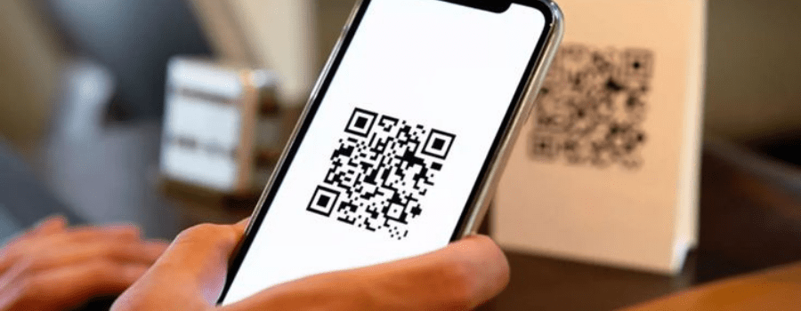 A hand scanning a UPI QR code on a smartphone, representing India's digital payments market