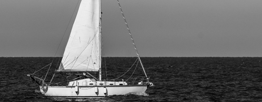 A lone sailboat on open water, representing a company navigating its public float